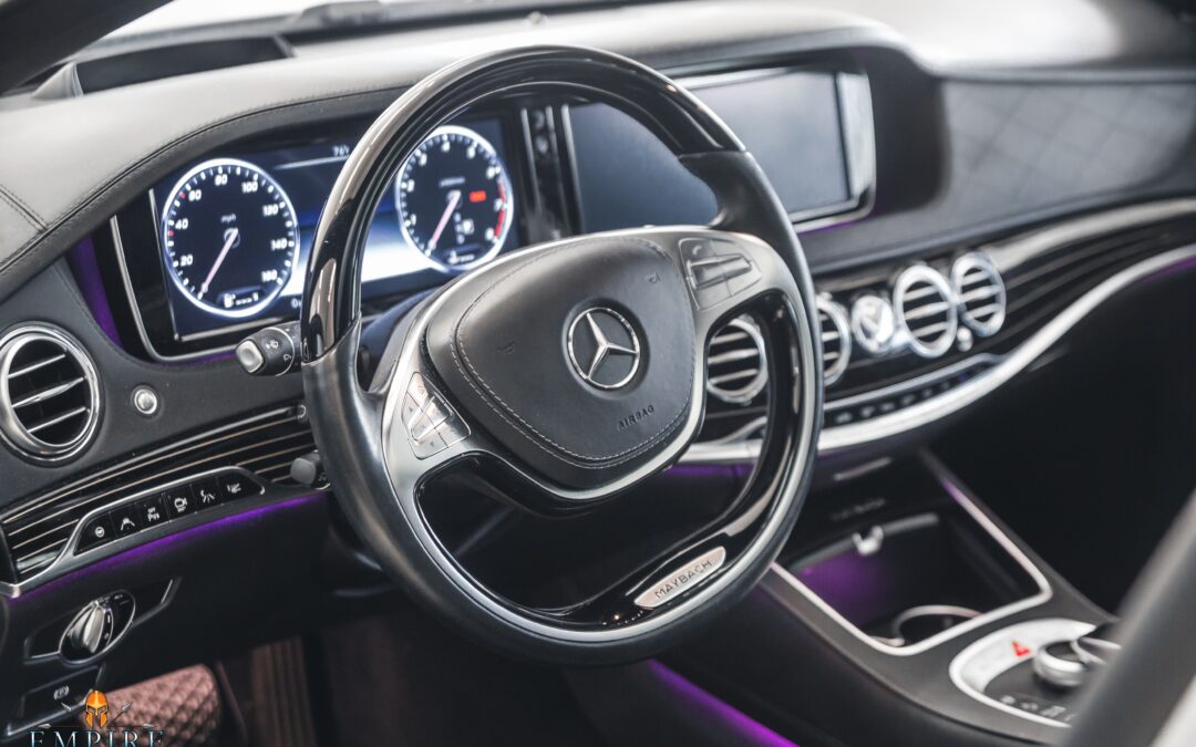 Freshly detailed interior of a Mercedes-Benz S-Class car. The seats are clean and free of wrinkles, the dashboard is polished, and the floor mats are vacuumed. The image also shows the M PURE logo on the steering wheel.
