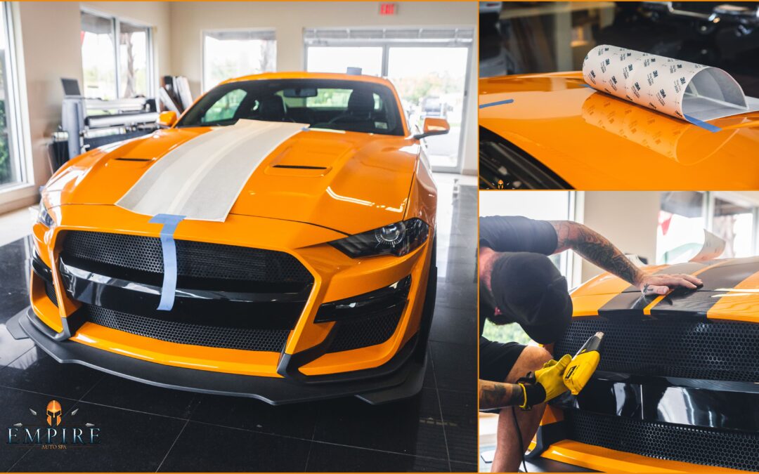 Empire Auto Spa technician expertly applying a vinyl wrap on a car, showcasing the transformation process.