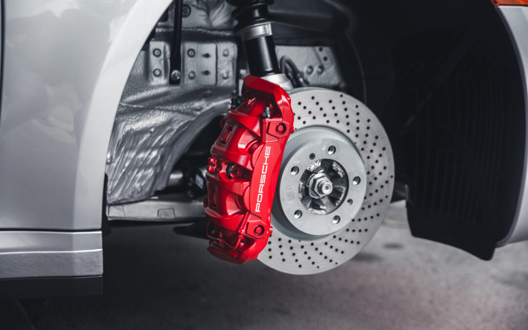 Empire Auto Spa technician meticulously cleaning and maintaining a car's brake caliper for optimal performance.