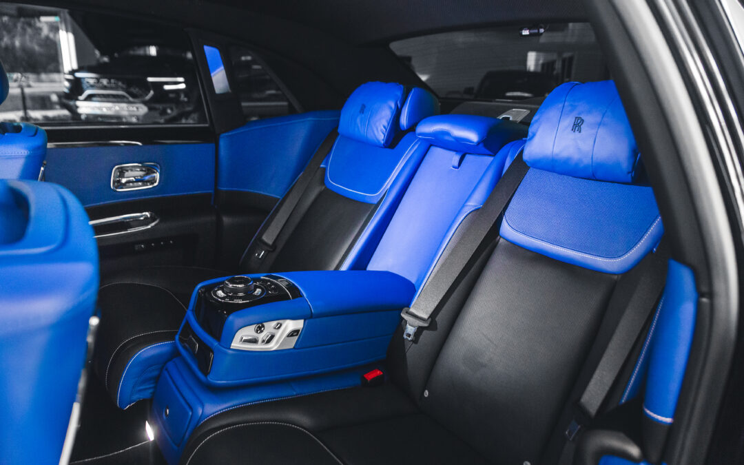 A black and blue car with blue seats. The interior of the car is being detailed.